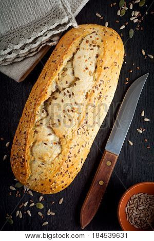 Healthy bread with bran sunflower seeds pumpkin flax and sesame seeds on an old wooden background. Top view. Selective focus.