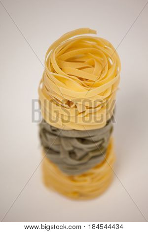 Roll of tagliatelle pasta on white background