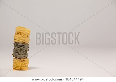 Roll of tagliatelle pasta on white background