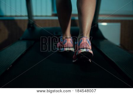 Close up of woman's legs on a treadmill in the gym.