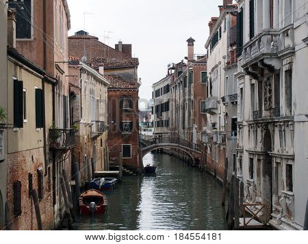 canal in venice with old buildings and boats