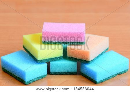 Colorful sponge for cleaning ware and house cleaning. Cleaning sponge with scrub set isolated on a wooden table. Closeup