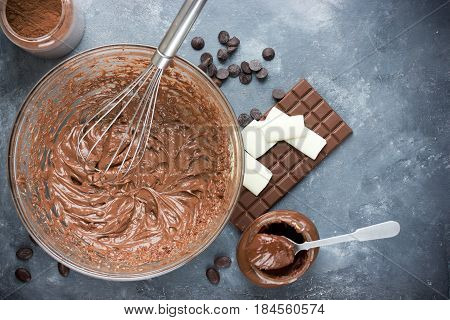 Chocolate cream in bowl and chocolate ingredients on the table top view