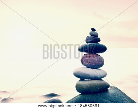Stacked Rounded Stones At Sea. Polished Pebbles On Dark Wet Rock,  Smooth Water