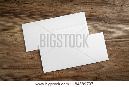 Blank paper envelopes on wooden table background. Front and back side. Template for your design. Top view.