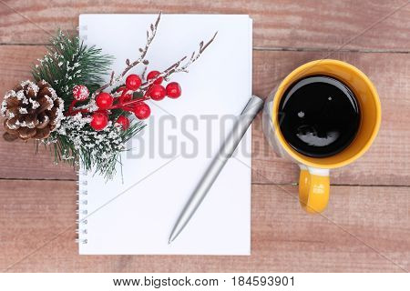 Pen and Notepad on the wooden desk. And cup of tea or coffee. Horizonal.