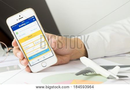 Bangkok Thailand - March 10 2017: Business man is using Booking.com application on his iPhone.