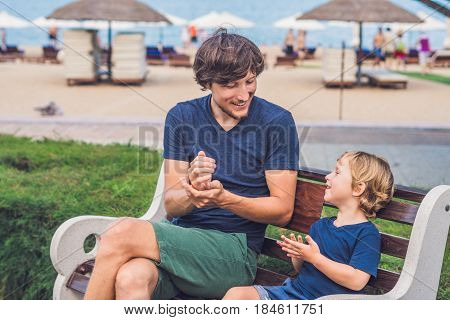 Father And Son Eat Fried Sweet Potatoes In The Park. Junk Food Concept