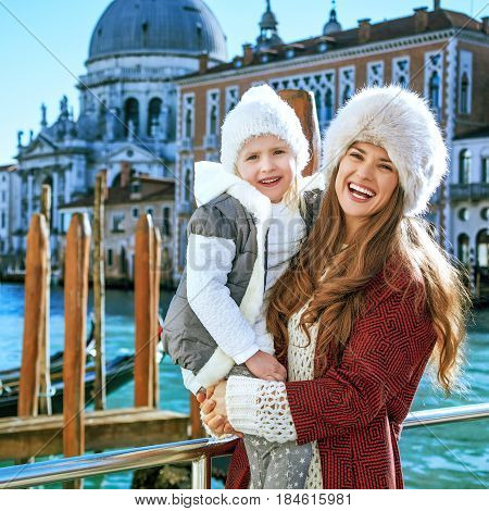 Mother And Daughter Standing On Embankment In Venice