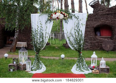 Beautiful Wedding Ceremony Outdoors. Decorated Chairs Stand On The Grass. Wedding Arch Made  Flowers