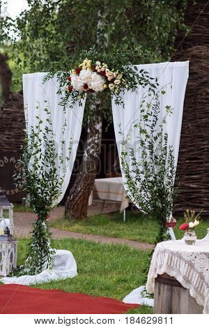 Beautiful Wedding Ceremony Outdoors. Decorated Chairs Stand On The Grass. Wedding Arch Made  Flowers