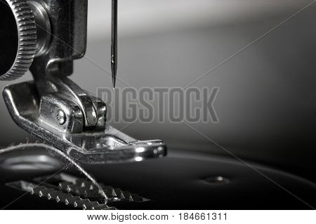 Get Needled: Macro photograph of part of a 1940's sewing machine. Sharp, detailed photo of the needle and pusher. Background layer suitable for multiple business and industrial applications or as wall hanging.