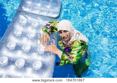 Muslim Arabic woman with burkini in pool