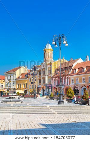 Brasov, Romania - March 24, 2015: The Orthodox Church of the Birth of the Mother of God at Council Square -Piata Sfatului - in downtown of Brasov and people near it