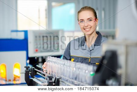 Female worker at a water bottling factory near conveyor