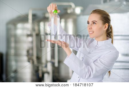 Specialist with bottle of pure water at a water factory