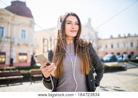 Lifestyle Fashion Portrait Of Young Stylish Hipster Woman Walking On Street Listen Music