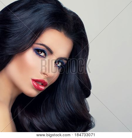 Glamorous Brunette Woman Fashion Model with Long Curly Hair and Red Lips Makeup