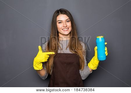 Smiling Woman Holding Bottle Of Chemistry For Cleaning House And Pointed On Isolated On Grey