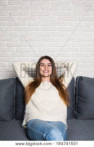 Closeup Of A Smiling Young Woman Lying On Couch At Home