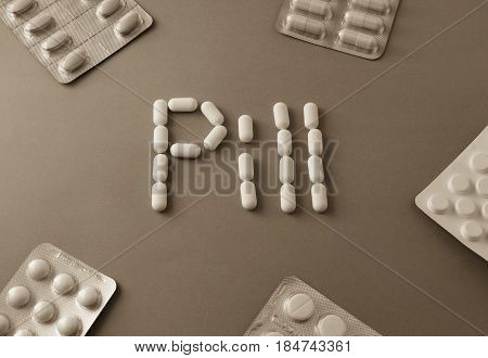 White Pills. Forming The Word - Pill. Near Are Tablets Over Grey Background