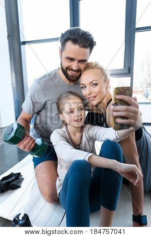 Girl Taking Self Portrait With Parents At Fitness Center