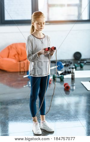 Young girl with skipping rope at fitness studio