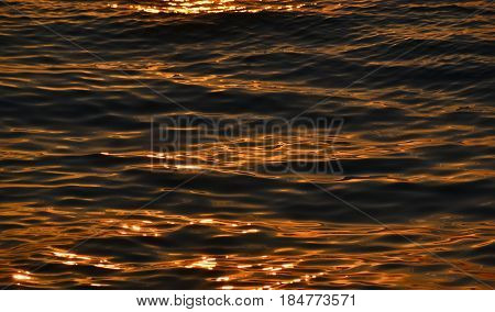 The surface of the water at sunset