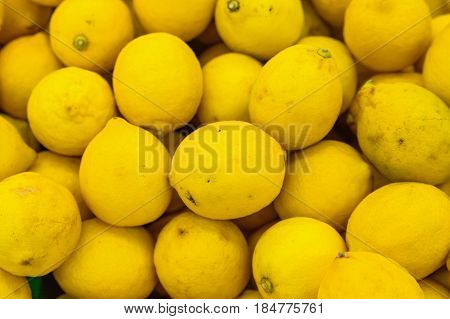 Bright ripe yellow lemons in supermarket background texture