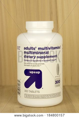 RIVER FALLS,WISCONSIN-MAY 02,2017: A bottle of Up and Up brand adult vitamins with a wood background.