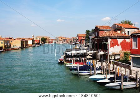 View of canal with boats in Murano island in Venice, Italy . Murano island is very popular touristic landmark in Europe .