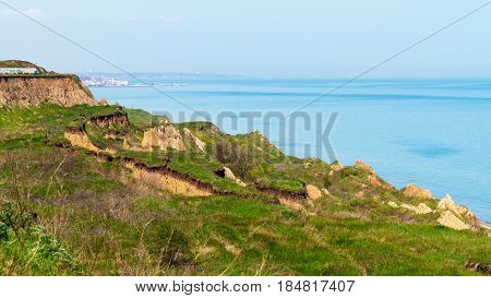 Deep Sandy Cliff On The Background Of Blue Sky. The Destruction Of The Coast As A Consequence Of Soi