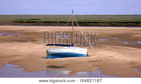 Boat on Sand Bank at East Fleet Estuary at The Quay in Wells-next-the-Sea in Norfolk