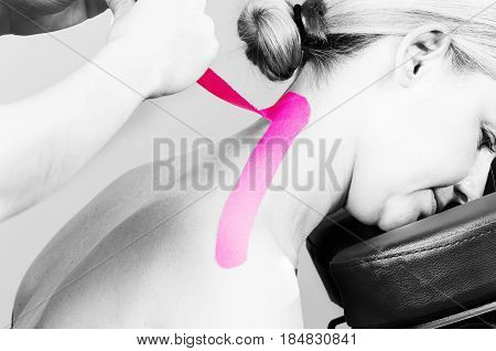 Fisiotheraphist/doctor Applying Cervical Kinesiotape In Silhouette Studio On White Background.