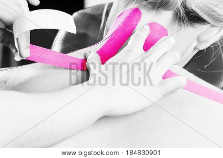 Fisiotheraphist/doctor Applying Cervical Kinesiotape In Silhouette Studio On White Background