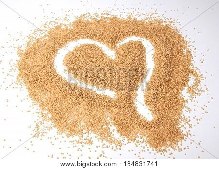 Amaranth seeds in a heart shape isolated on white background