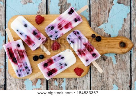 Homemade Mixed Berry Yogurt Popsicles On A Paddle Board With Rustic Wood Background