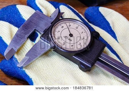 Slide caliper with round dial on a working glove