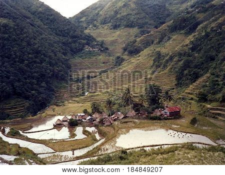 An Ifugao village stands at the bottom of a valley below the ancient rice terraces, carved into the mountains, near the city of Banaue, Ifugao Province, in the Philippines.