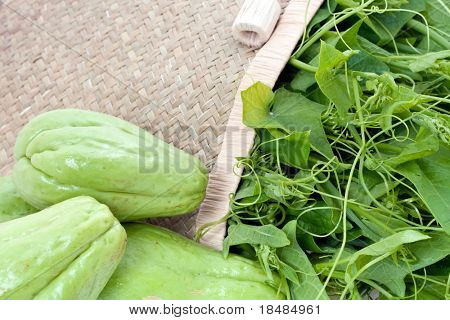 Chayote สดกับพืชนำในตะกร้าหวาย