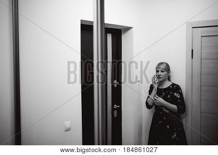 Blonde Woman Answers The Intercom Call, Hold The Phone To His Ear, Waiting For The Arrival Of The Lo