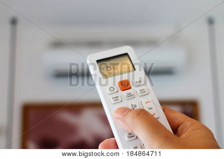 hand holding remote controller to adjust temperature