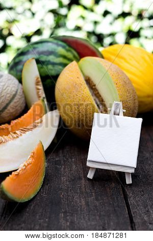 various delicious melons and slices of melons with empty sign