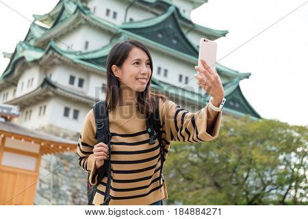 Woman taking photo with Nagoya castle 