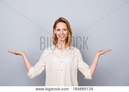 Photo Of Young Pretty Woman Showing Difference Between Two Products On Her Hands Against Gray Backgr