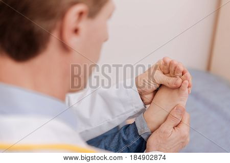 Tiny and neat. Nice careful experienced rheumatologist conducting treating procedure and rubbing childs feet for stimulating her joints