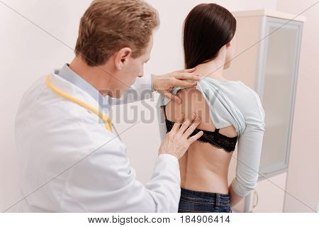 Adult consultation. Experienced prominent nice rheumatologist using his skill for identifying diagnosis while having a look on ladies spine