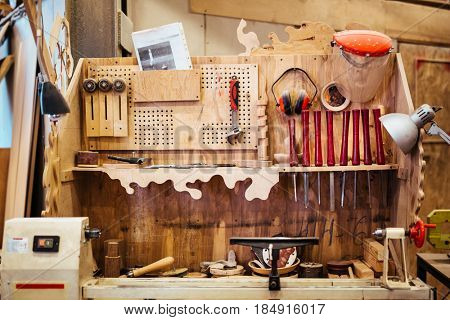 Background image of woodworking workshop: carpenters work table with different tools and wood cutting stand