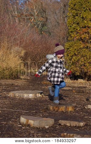Adorable school age girl playing outside in winter coat and hat