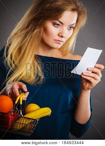 Worried Woman Holding Shopping Basket With Fruits
